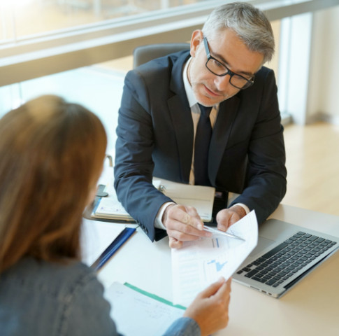 Woman in banker's office signing financial loan for project